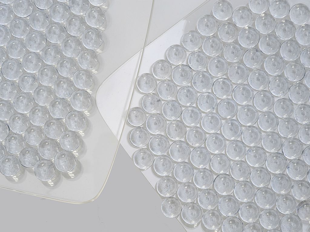 Simply pouring small acrylic balls onto two plates provides an illustration for how perfectly self-assembled they become. Felice Frankel